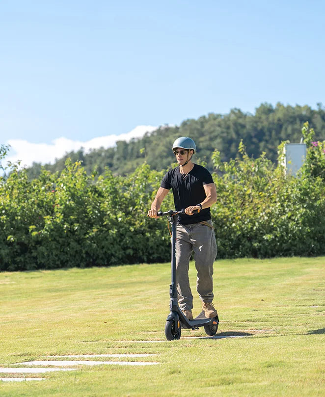 Male commuter enjoying CUNFON RS300 electric scooter on countryside road, showcasing 500W hub motor, 20-30KM range, and reliable performance for daily green transportation.